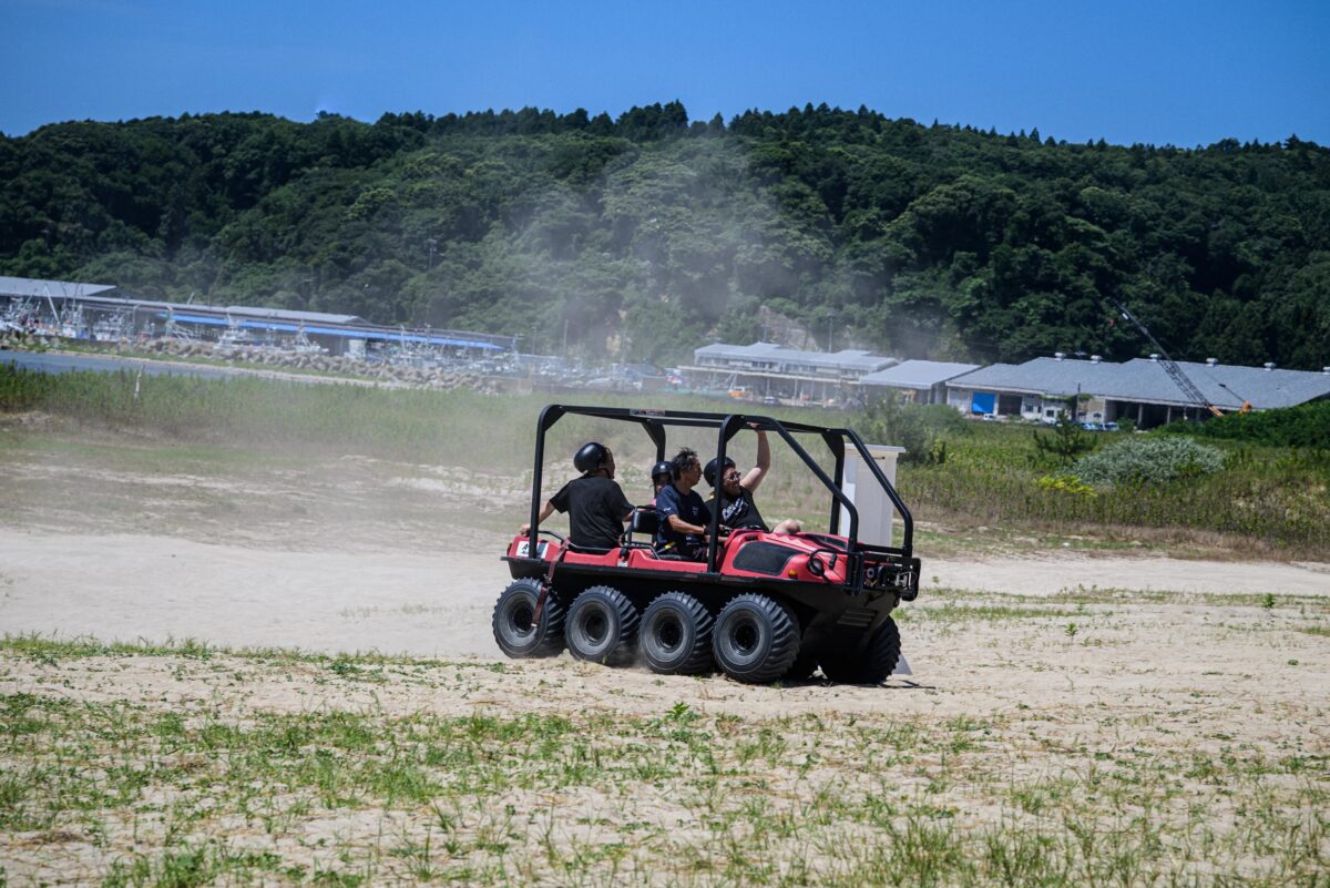 すごい勢いで砂浜を疾走する8バギーを楽しむ人々