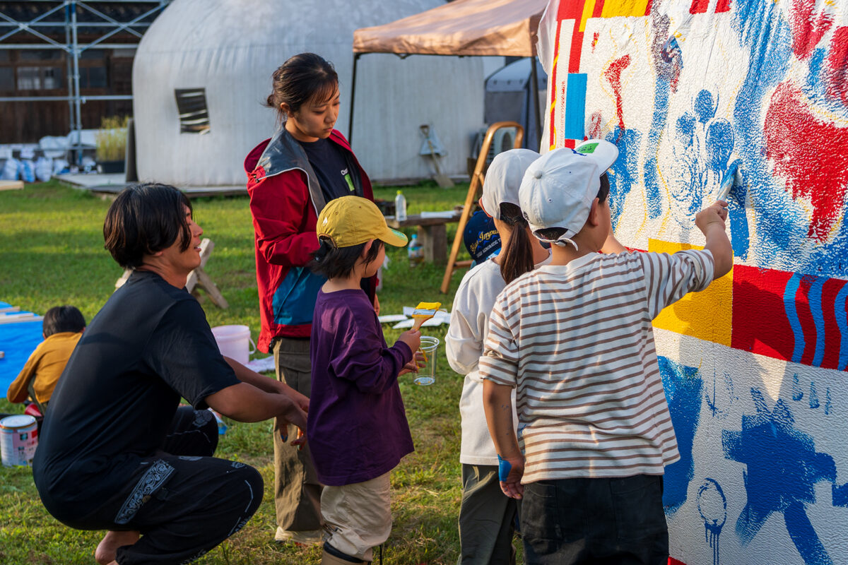 畠山さん（左）と一緒に壁画アートを制作する子どもたち（撮影：2025年10月　「はじめたいこと、はじめよう！プロジェクト」提供）