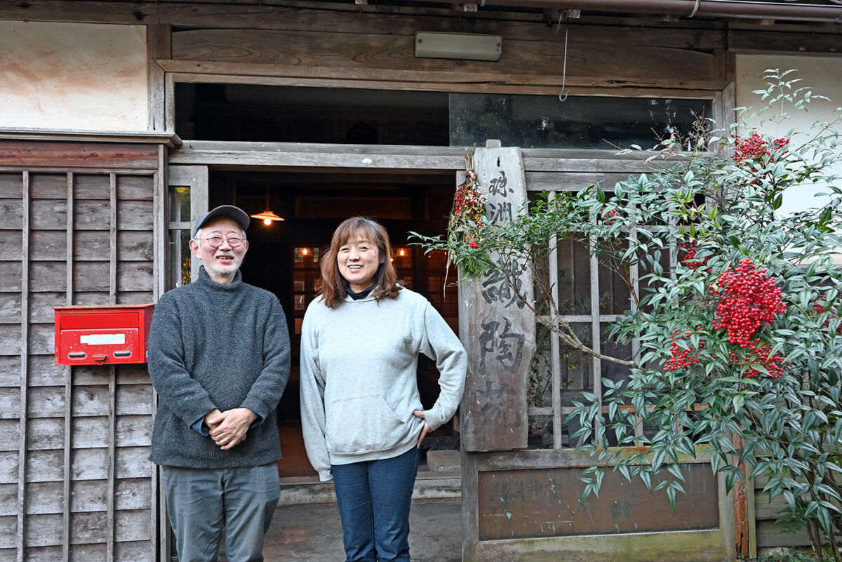 玄関前に立つ市郎さんと信子さん。市郎さんと父が珠洲焼の窯元「珠洲 伏見窯」を、母が綴れ織の工房を、信子さんがレストラン典座を営み、これらを「珠洲 織陶苑」と総称した