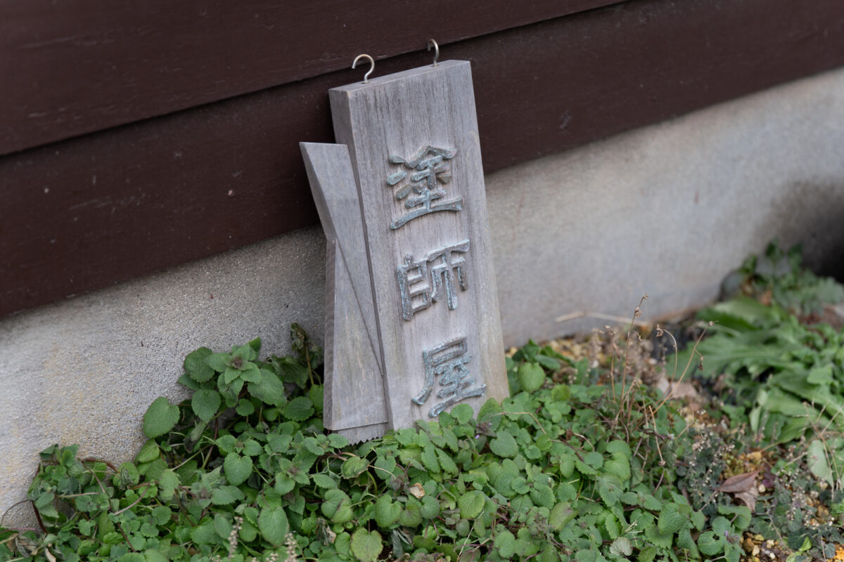 地震で地面に落ちたままの塗師屋の看板