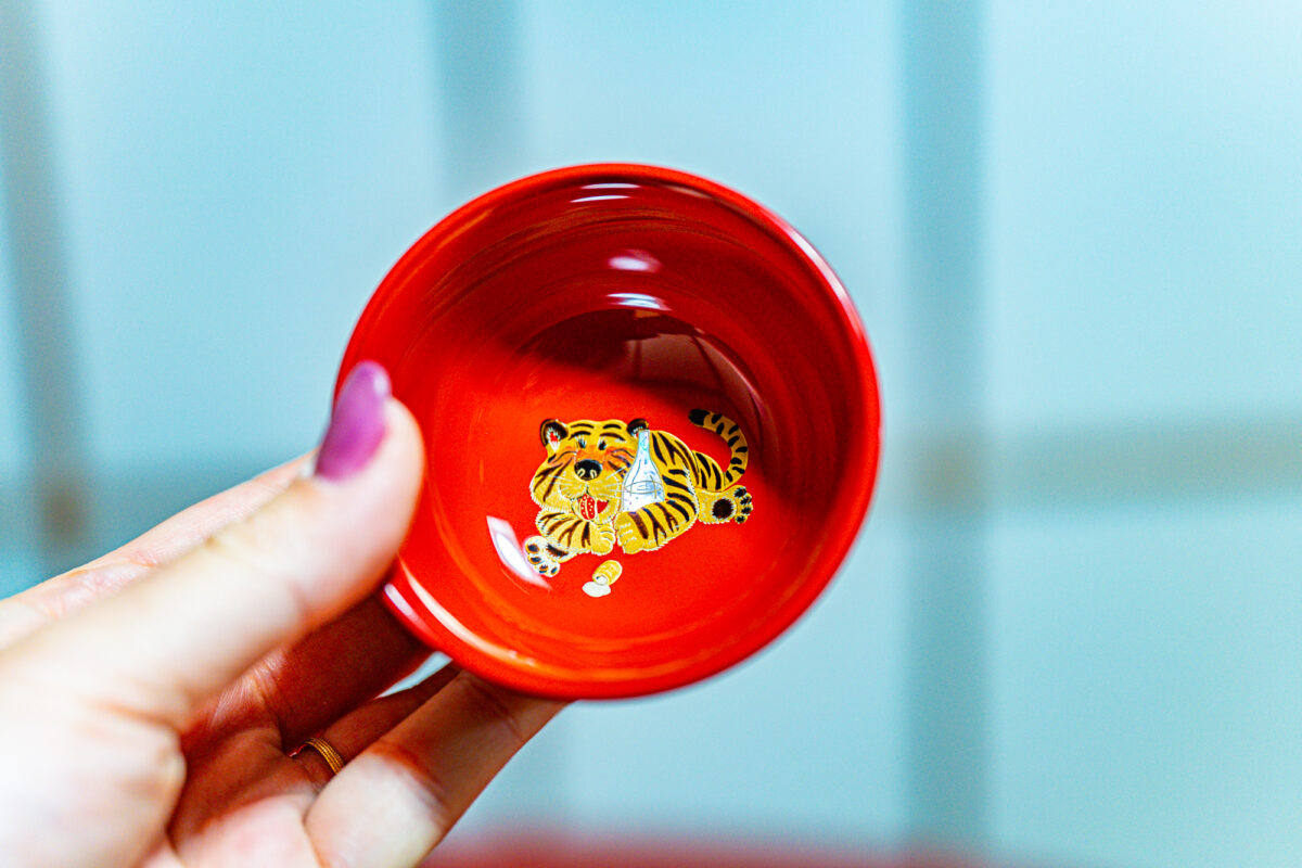 酒瓶を抱えて頬を赤くする虎。干支の蒔絵が描かれた人気の杯