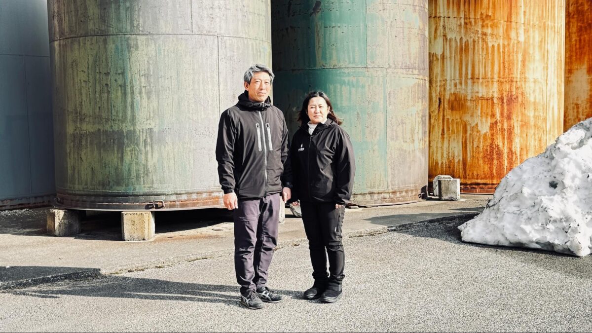 焼酎が寝かされているタンクの前で。夫婦二人三脚で苦難に立ち向かいます