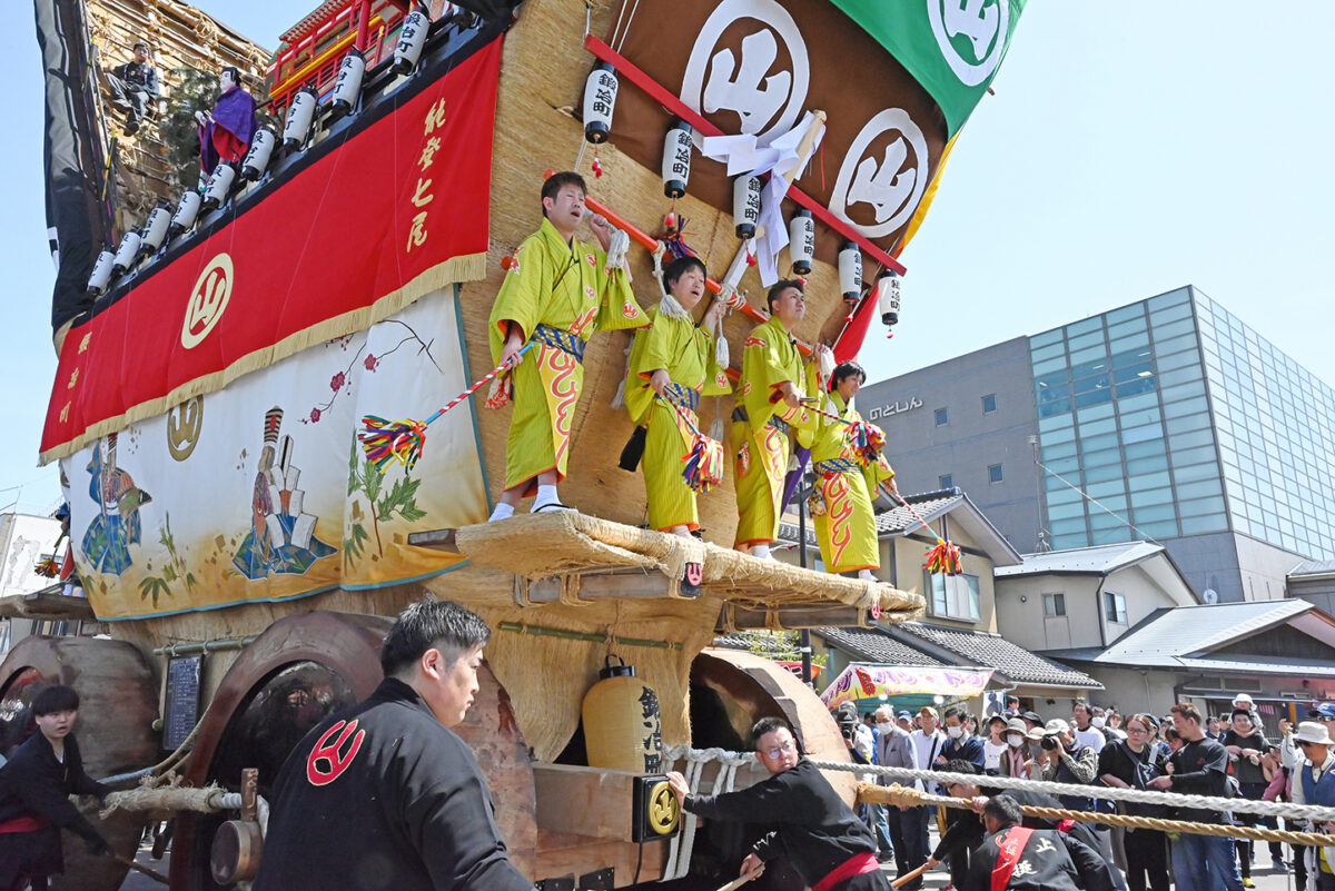 青柏祭(せいはくさい)では祭りの花形・木遣り衆として「でか山」の台に上り、曳き出しや辻回しなどの見せ場で伝統の木遣り唄を披露する明能さん。2024年は震災で「でか山」の巡行がなくなったが、ミニサイズの「でか山」を作り、子どもたちが曳き回すイベントが開催され、その裏方として汗を流した