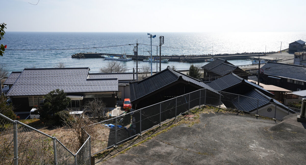 能登半島の東側・富山湾側に「内浦」と呼ばれる地域に位置する三波地区(住所は能登町波並)。左手に見える瓦屋根の建物が公民館。2021年に建て替えられた(撮影:2026年2月 関口威人)