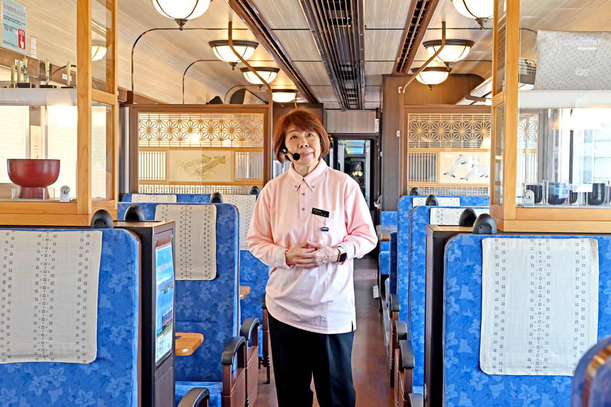 「のと里山里海号」で語り部をつとめる宮下左文さん。列車内の輪島塗、田鶴浜建具、珠洲焼、能登上布なども「この列車がどんな土地を走っているのか」を静かに物語っている
