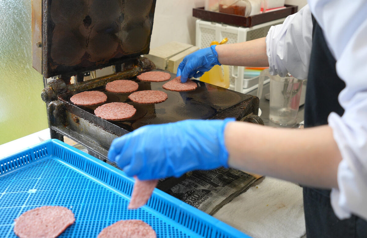焼き機で焼き上がったばかりのいか煎餅。この後の乾燥工程も重要(撮影:2026年3月 関口威人)